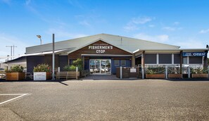 A building with a sign reading 'Fishermen's Coop' and a 'Take Away Open' sign.