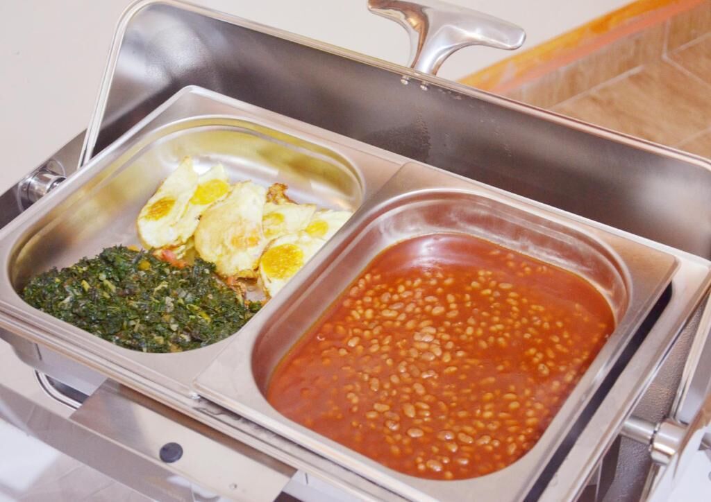 Un buffet con tre piatti: verdure verdi, uova fritte e fagioli al forno.