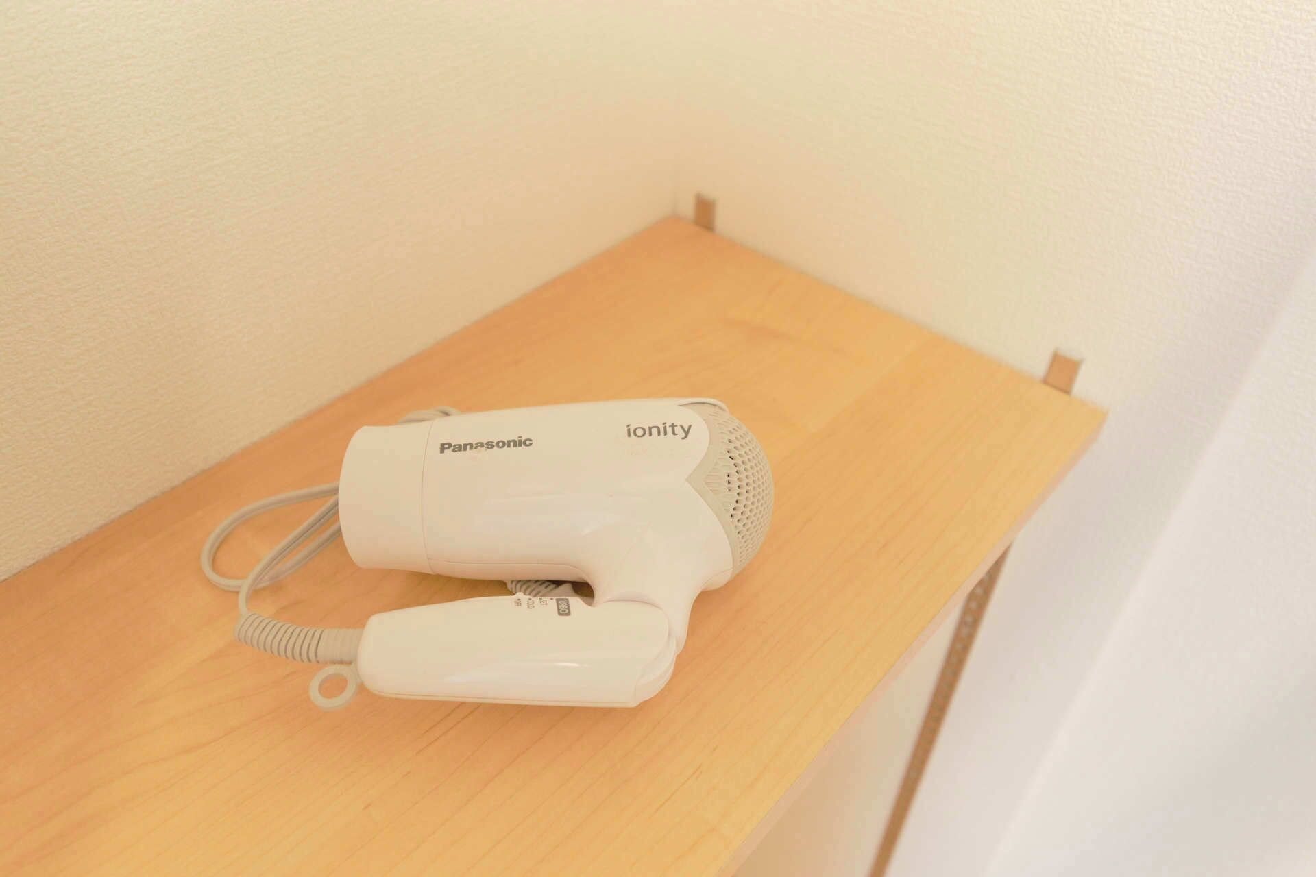A Panasonic ionity hair dryer on a wooden table.