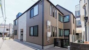 A modern two-story residential building with a flat roof, large windows, and a gated entrance. - Nakano Five by Tranova (Tokyo)