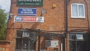 A brick building with multiple signs advertising a bar, restaurant, and sports channel. - The Broadway Rooms  (Leicester)