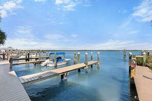 A marina with boats docked, wooden piers, and calm water. - The Riverside Club - B206 (Marco Island)