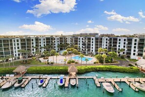 Un complejo turístico con varias edificaciones, piscina y un muelle con barcos.