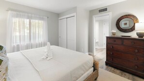 Ein Schlafzimmer mit einem großen Bett, einem Schminktisch und einem Spiegel an der Wand.
