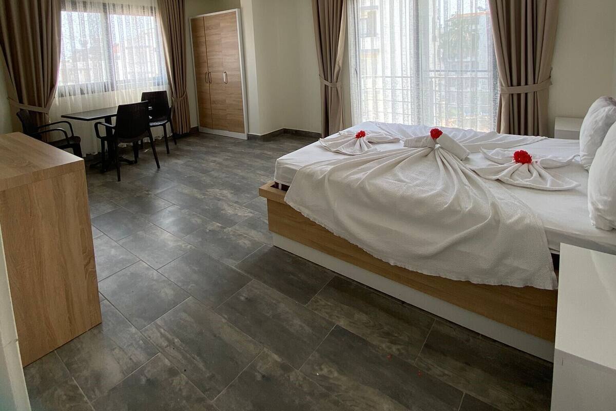 A hotel room with a bed, a desk, and chairs.