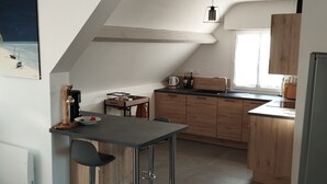 Une cuisine moderne avec un coin bar, des meubles en bois et une grande fenêtre.