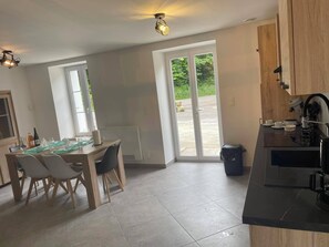 Una cocina moderna con comedor, ventanas amplias y vistas al exterior.