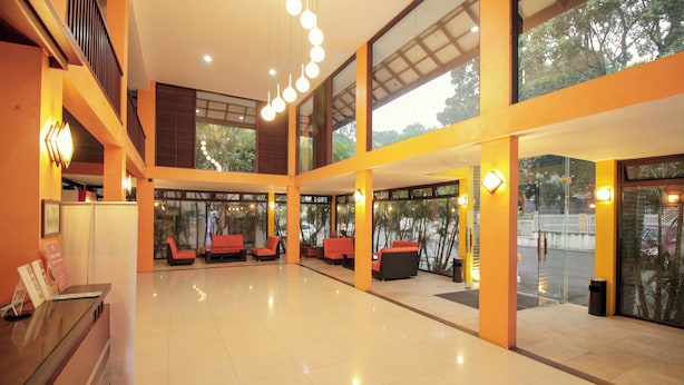A spacious lobby with a reception desk, seating areas, and large windows offering views of the outdoors. - Collection O 295 Grha Ciumbuleuit Guest House (Bandung)