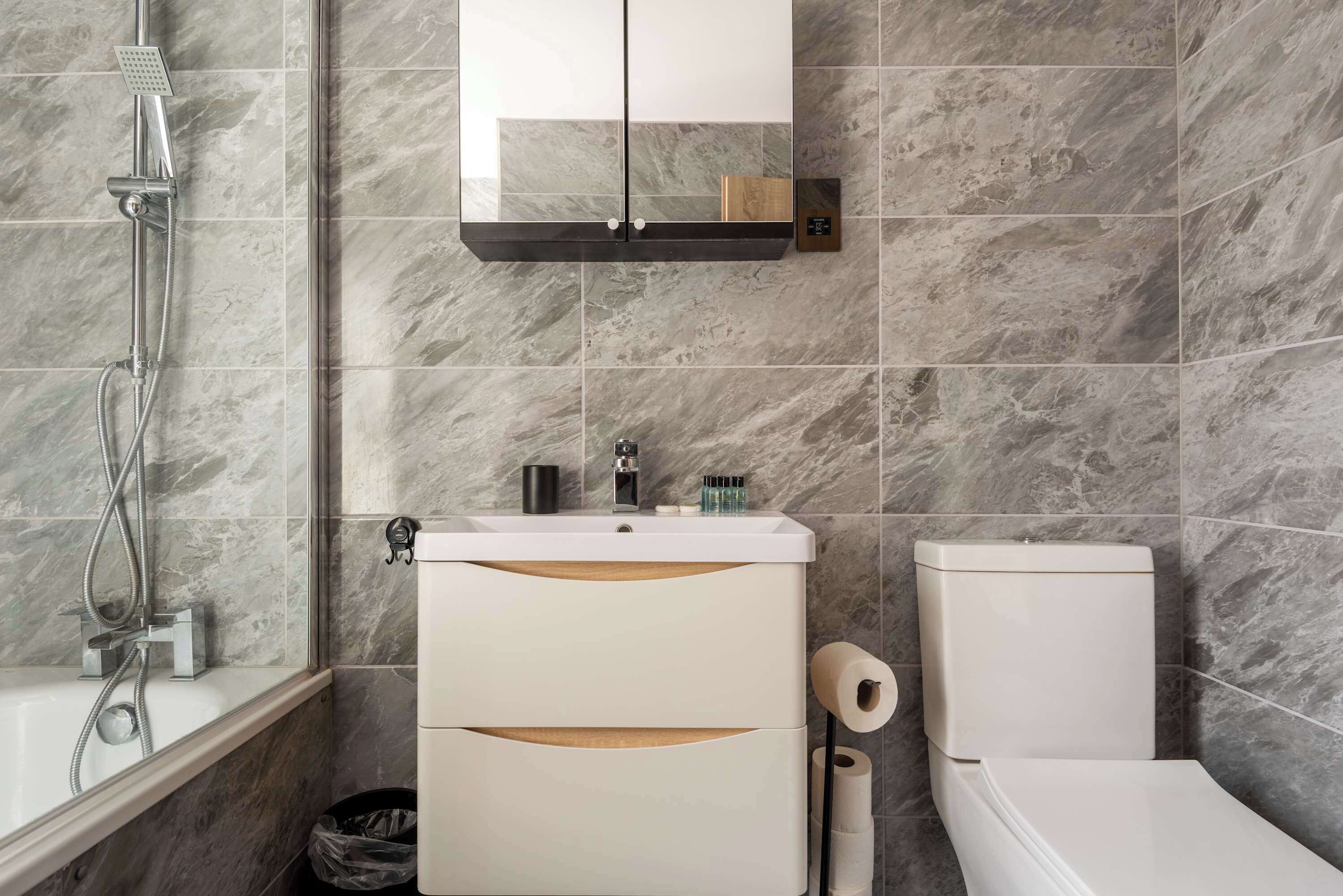 Ein Badezimmer mit Dusche, Toilette und Waschbecken.