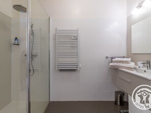 A modern bathroom with a glass shower enclosure, a white towel rack, and a sink with a mirror. - Charming Stay with Pool in Loire Valley's Wine Region (Dou é-en-Anjou)