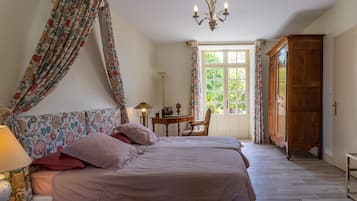 Une chambre à coucher comprenant un lit, un bureau, une chaise, un téléviseur et une armoire.