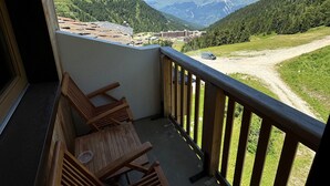 A balcony with wooden chairs and a view of a mountainous landscape. - Renovated 2-Room Ski-In/Ski-Out Apt with Pool & Wellness Center (Belle Plagne)