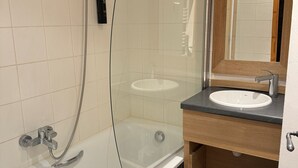 A modern bathroom with a glass-enclosed shower, a white sink, and a wooden vanity. - 3BR Apartment · 70m² · Ski-in/Ski-out · Pool · Pets allowed (Belle Plagne)