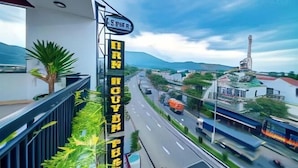 Un letrero de hotel con vistas a un paisaje urbano, incluyendo una autopista y montañas.