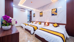 Habitación de hotel con dos camas, suelo de mármol, aire acondicionado de pared y un arreglo floral.