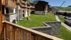 Ein Hotel mit Holzbalkonen, Steinmauern und Bergblick.