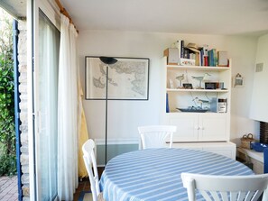 Enjoy a comfortable stay in this well-organized room with a dining area, featuring a large window, bookshelves, and a framed map.
