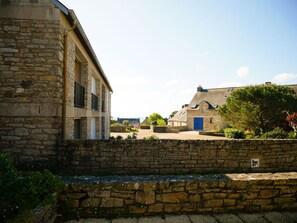 Experience the charm of a traditional stone building with a prominent entrance, set amidst well-maintained gardens.