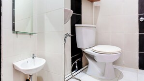 Un baño con un lavamanos blanco, un inodoro y un espejo.