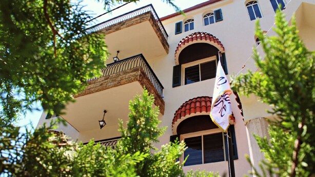 A multi-story building with balconies and arched windows. - Alpine hotel  (Qabr Chamoun)