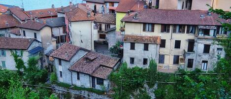 Um conjunto de edifícios tradicionais com telhados de terracota, alguns com varandas, dando vista para um corpo de água.