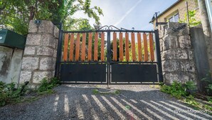 A gated entrance with a stone wall, a wooden gate, and a metal gate. - Villa with outbuildings close to the lake and shops. (Savines-le-Lac)