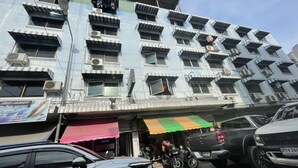 Een meerlaags gebouw met balkons en airconditioners.