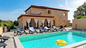A pool area with lounge chairs and a yellow float. - MOLAROTTO CAMERE CON ANGOLO COTTURA (San Teodoro)