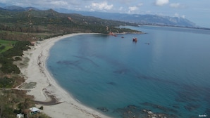 A coastal landscape with a sandy beach, clear blue waters, and distant mountains. - Bosa Marina Fronte Mare (Bosa)