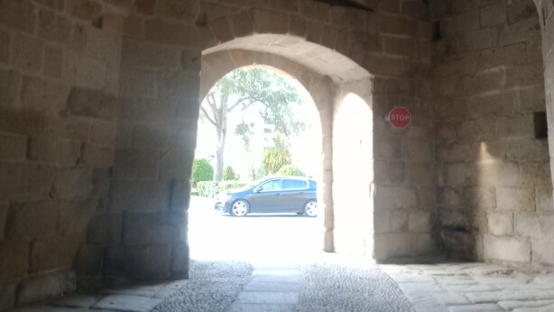 An arched stone structure with a stop sign visible.