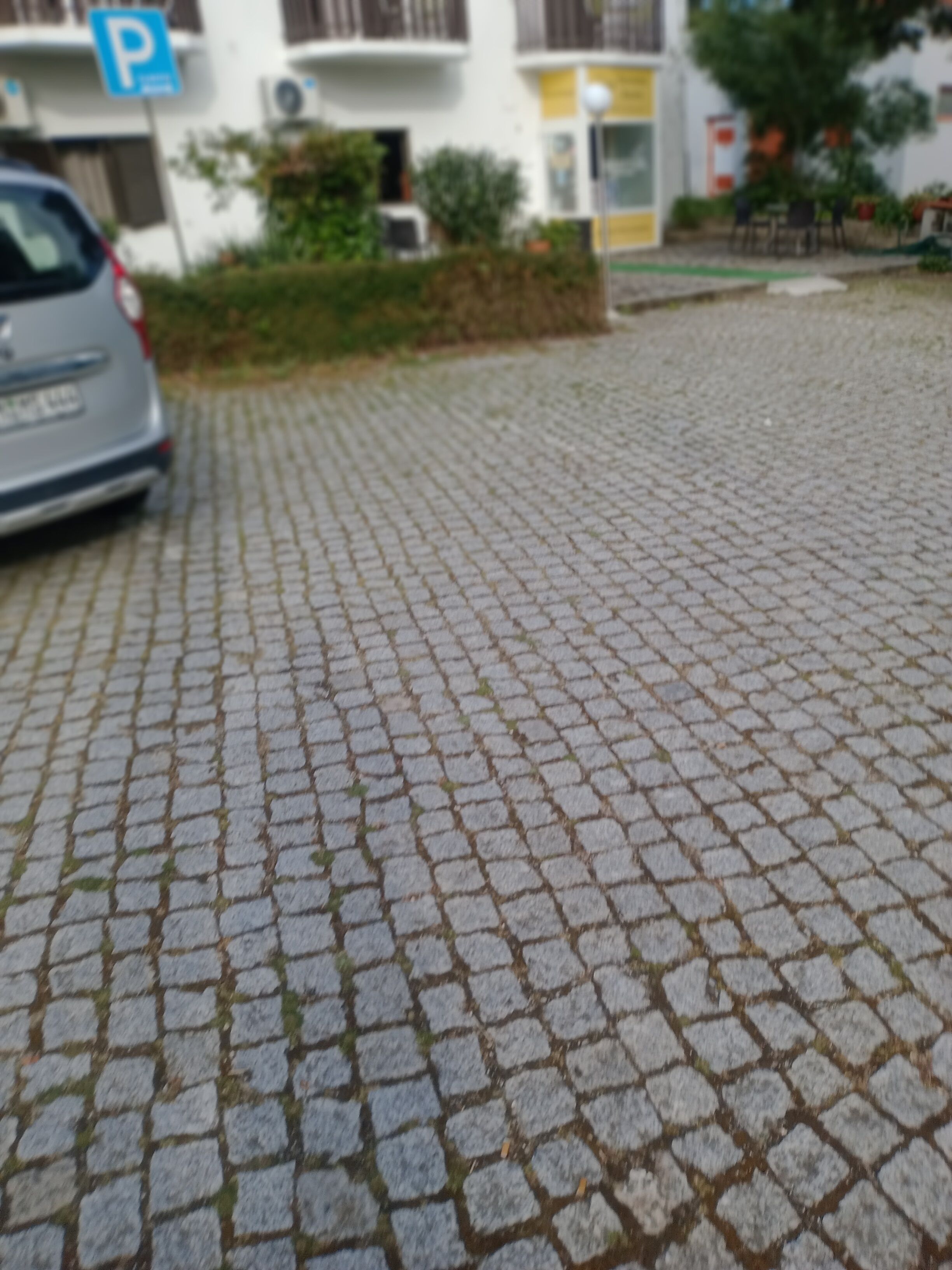 Un área pavimentada con un coche aparcado al lado.