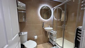 Un baño moderno con inodoro, lavabo y ducha.