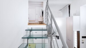 Eine moderne Treppe mit Glastrennwand und Holzvertäfelung.