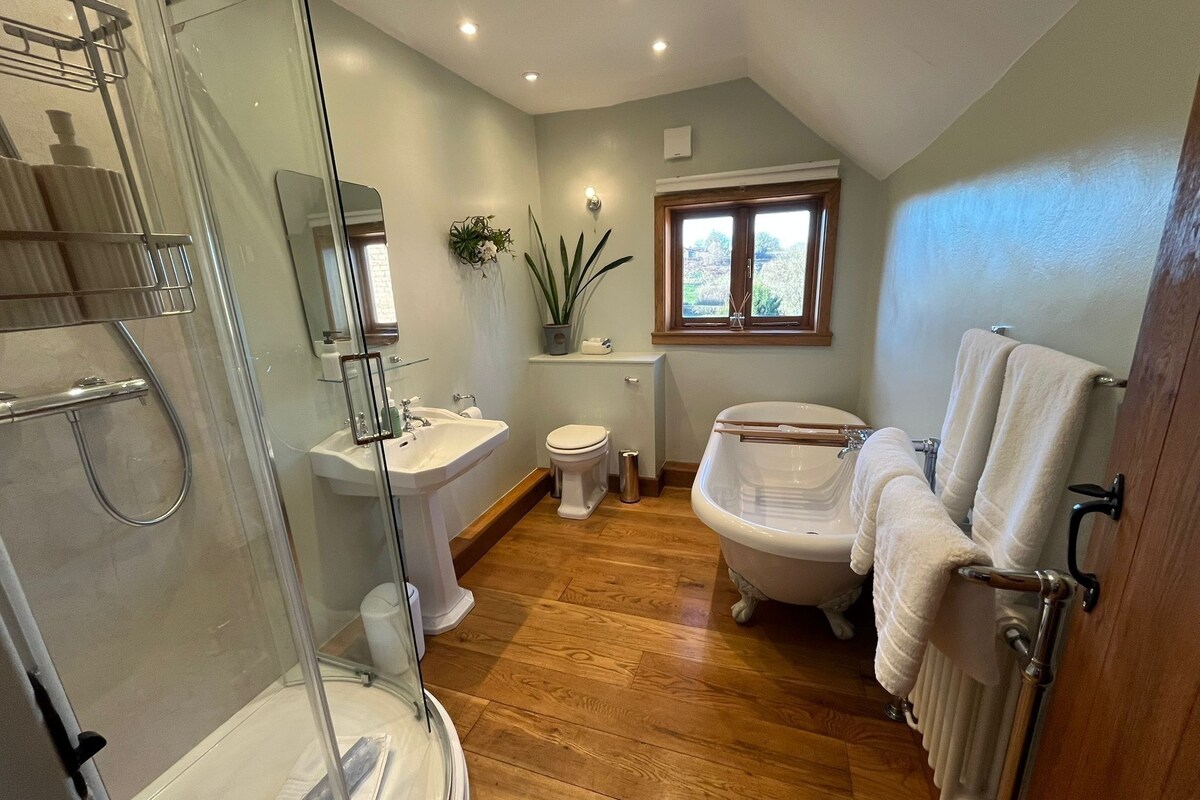 A bathroom with a glass shower enclosure, a sink, toilet, and a bathtub.