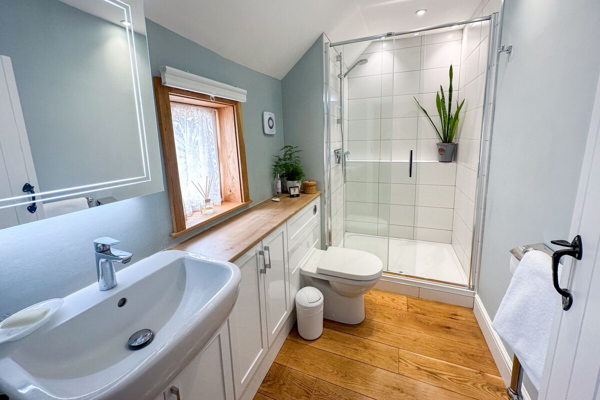 A modern bathroom with a sink, toilet, and shower.