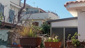 Ein Wohngebäude mit Balkon, Blumentöpfen und blauem Himmel.