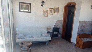 Ein Wohnzimmer mit einer Couch, einem kleinen Tisch und einem Kamin.