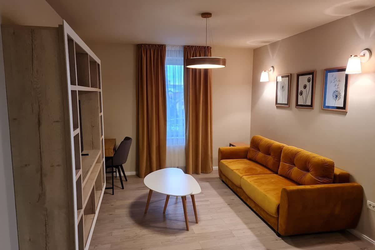 Ein modernes Wohnzimmer mit Sofa, Esstisch und Bücherregal.
