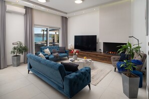 A modern living room with a sofa, a coffee table, and a television.