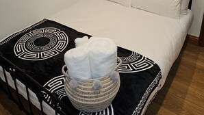 A neatly made bed with white linens and a black and white patterned throw. A white towel is placed on the bed. - Primely Located 1-bed Apartment in Brighton (Brighton)