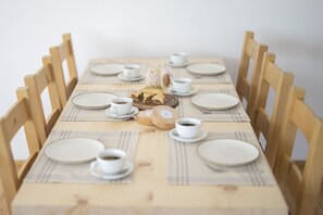 Una mesa de comedor dispuesta con platos, tazas y un adorno central.