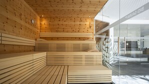 A modern interior with wooden slatted benches and a glass wall with a logo. - Chasa Helvetia Studio: Relax and enjoy in the new studio with exclusive hotel service (Müstair)