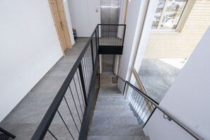 A staircase with metal railings, a wooden door, and a view of a building exterior. - Chasa Helvetia Studio: Relax and enjoy in the new studio with exclusive hotel service (Müstair)