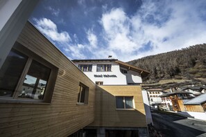 A hotel with a wooden facade, multiple windows, and a sign reading "Hotel Helvetia."