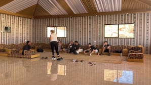 A spacious room with patterned walls, a large window, and a tiled floor.