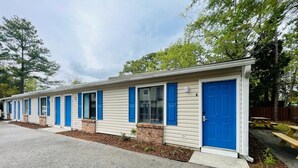A row of mobile homes with blue doors and windows, arranged in a linear fashion along a gravel driveway. - Sunny Getaway * 1BR condo close to the beach (B) (Myrtle Beach)