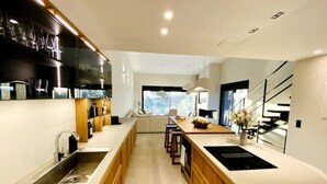 Una cocina moderna con una isla central, armarios de madera y una estufa empotrada.