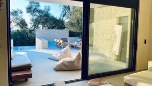 Una habitación moderna con puerta de vidrio que da a un espacio exterior con piscina.