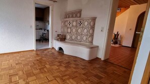 A room with a wooden parquet floor, a white wall, and a built-in cabinet with circular cutouts. - Completely Renovated House From 22 Euro pp and day (Baden-Baden)