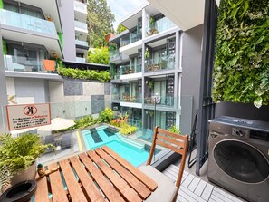 A modern apartment with a glass-bottomed pool, outdoor seating, and a vertical garden.